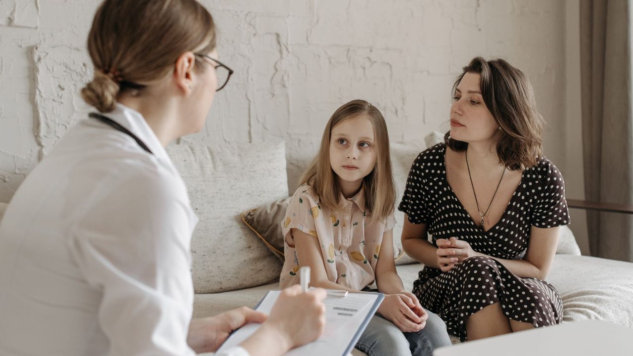 A clinician talking with a mother and her young child during an appointment
